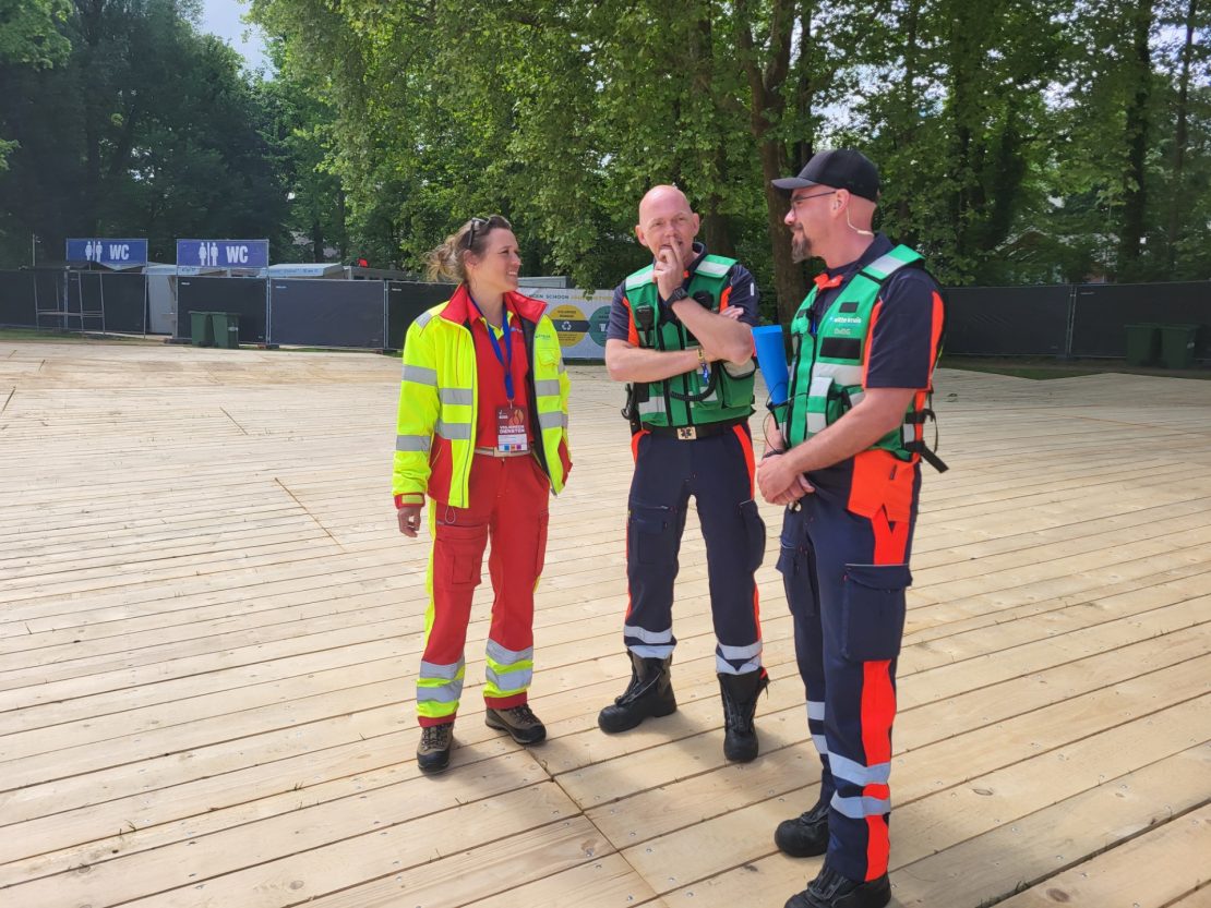 Arts Witte Kruis evenementenzorg in gesprek met collega's op evenement
